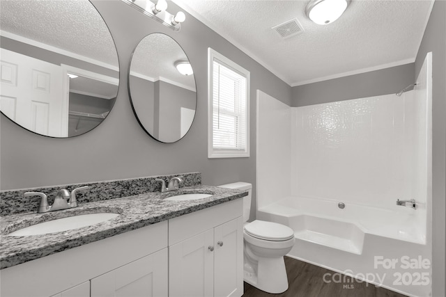 bathroom with toilet, visible vents, a sink, and wood finished floors