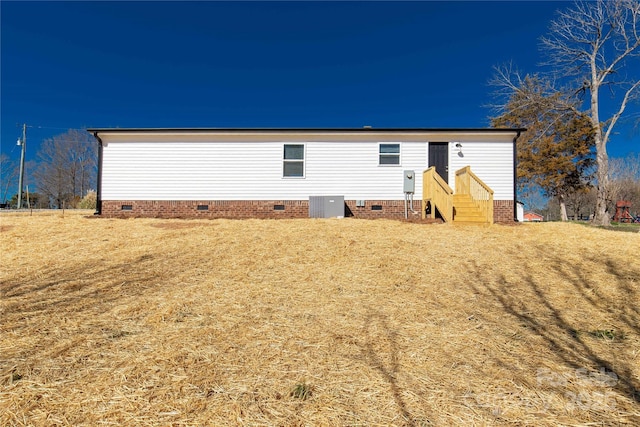 back of house with crawl space and central air condition unit