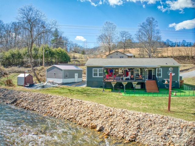 view of front of house featuring an outbuilding and a front lawn