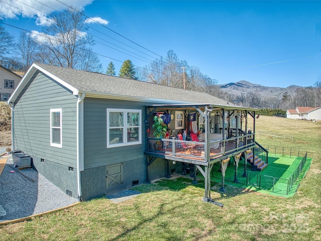 rear view of house with a yard, crawl space, fence, and roof with shingles