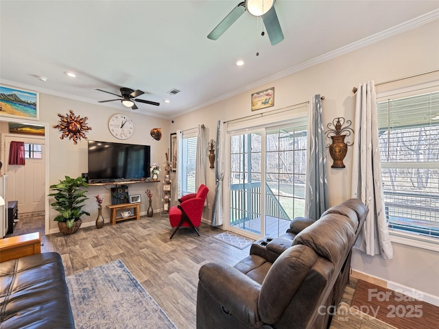 living room featuring baseboards, crown molding, and wood finished floors