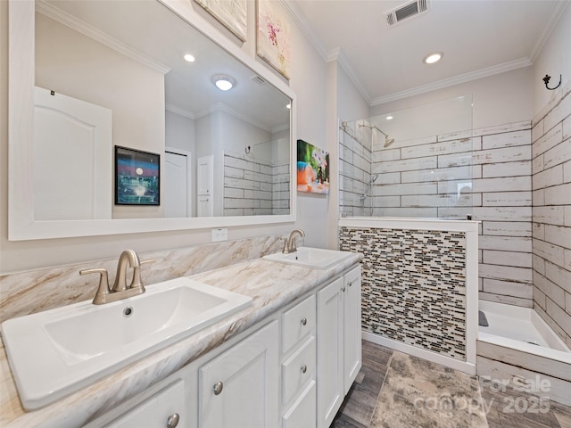 full bath featuring ornamental molding, visible vents, a sink, and a walk in shower