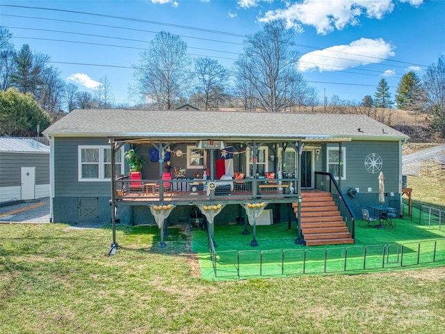 rear view of house featuring a yard, stairway, and fence