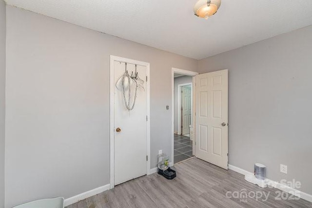 unfurnished bedroom featuring light wood-style flooring and baseboards