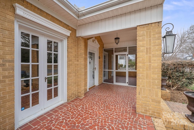 exterior space with french doors and brick siding