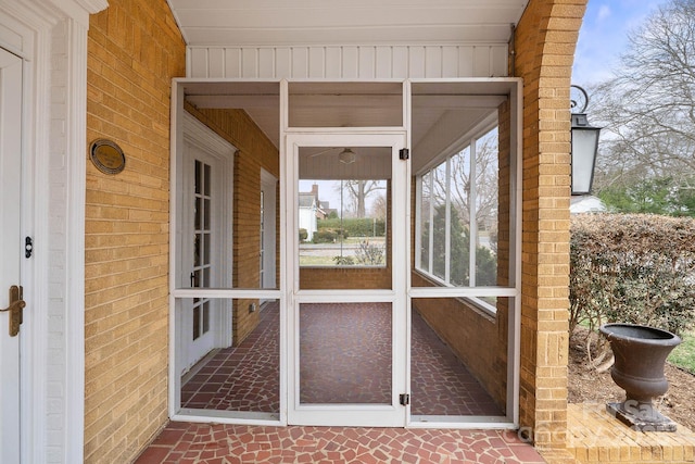 view of exterior entry featuring brick siding