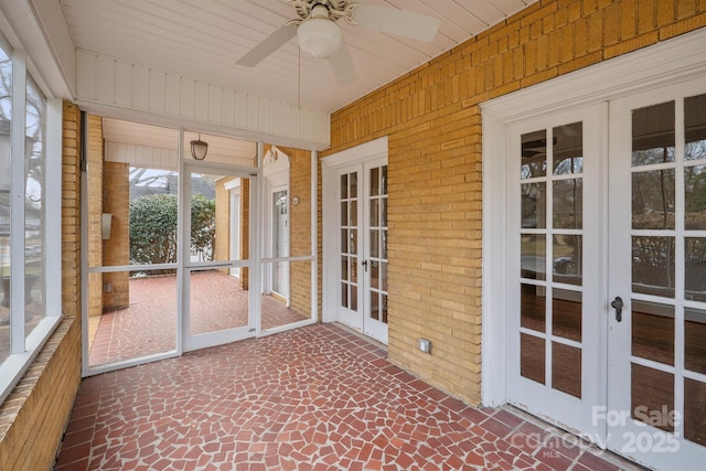unfurnished sunroom featuring a ceiling fan