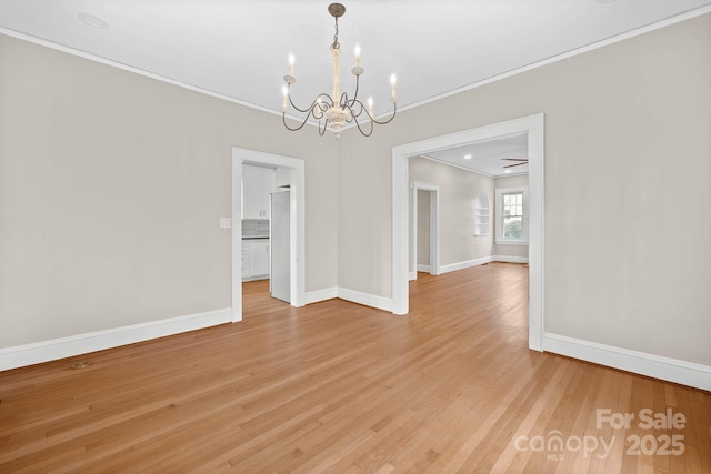 unfurnished dining area featuring a notable chandelier, crown molding, light wood-style flooring, and baseboards