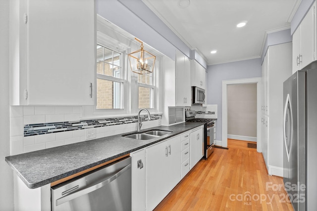 kitchen with dark countertops, decorative backsplash, appliances with stainless steel finishes, ornamental molding, and a sink