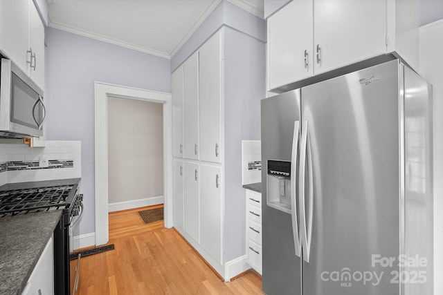 kitchen featuring tasteful backsplash, dark countertops, light wood-style flooring, stainless steel appliances, and crown molding