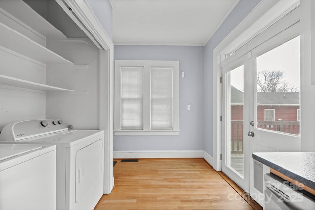 washroom featuring a wealth of natural light, baseboards, light wood finished floors, and separate washer and dryer