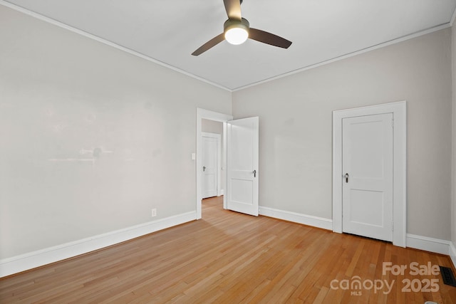 unfurnished bedroom featuring ornamental molding, baseboards, ceiling fan, and hardwood / wood-style floors
