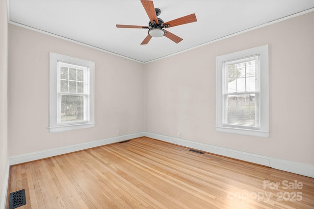 unfurnished room with light wood finished floors, baseboards, visible vents, and a ceiling fan