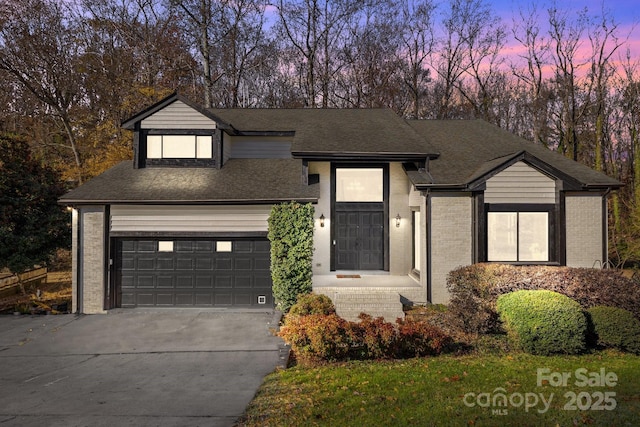 view of front of property with a garage, concrete driveway, brick siding, and a shingled roof