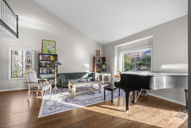 sitting room featuring high vaulted ceiling, wood finished floors, a wealth of natural light, and baseboards