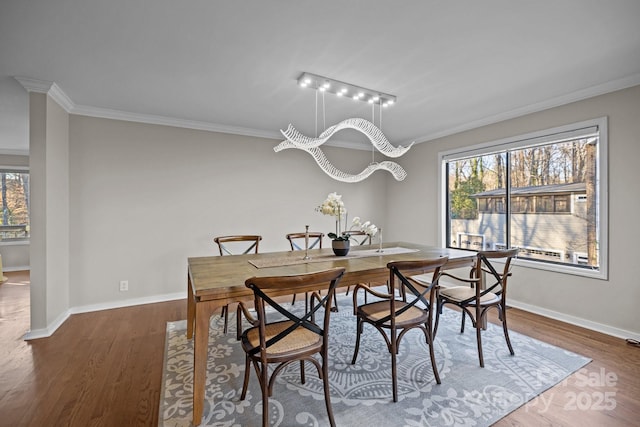 dining space featuring dark wood-type flooring, a wealth of natural light, and ornamental molding