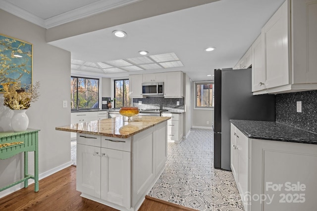 kitchen featuring white cabinetry, stainless steel appliances, and light stone counters