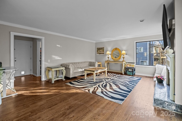 living room featuring crown molding, baseboards, and wood finished floors