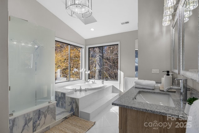 full bathroom featuring visible vents, lofted ceiling, tile patterned floors, a garden tub, and vanity