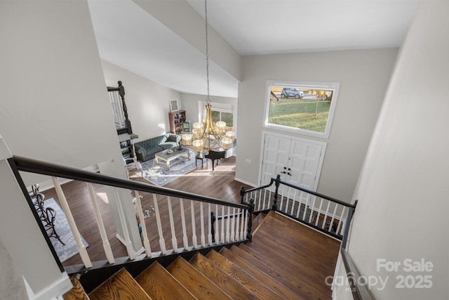 stairs with a chandelier, baseboards, and wood finished floors