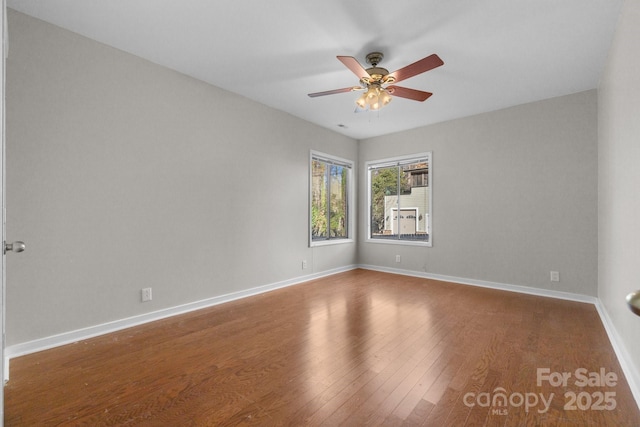 spare room with a ceiling fan, baseboards, and wood finished floors