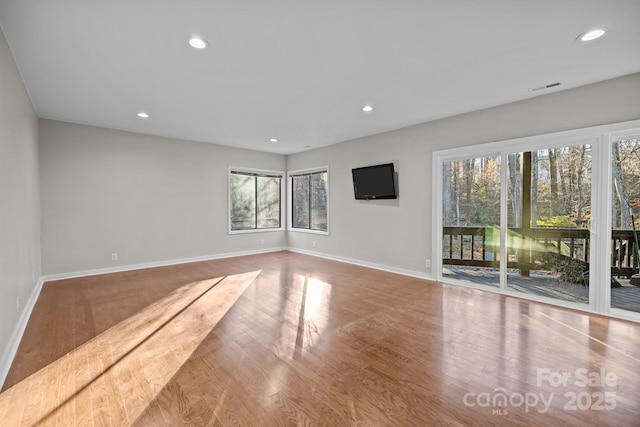 unfurnished living room with baseboards, light wood finished floors, visible vents, and recessed lighting