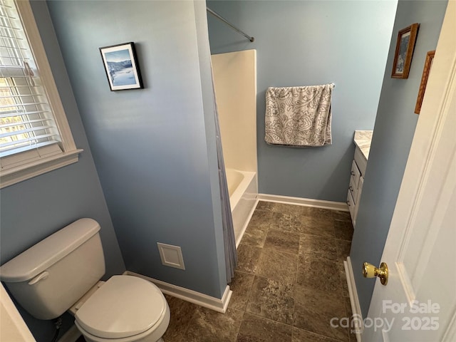 bathroom featuring tub / shower combination, baseboards, toilet, stone finish floor, and vanity