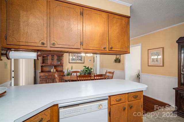 kitchen featuring brown cabinets, light countertops, and dishwasher