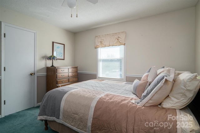 carpeted bedroom featuring a textured ceiling and ceiling fan