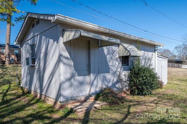 view of side of property featuring cooling unit and a yard