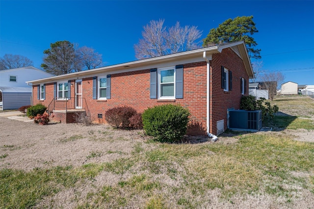 single story home with crawl space, a front lawn, cooling unit, and brick siding