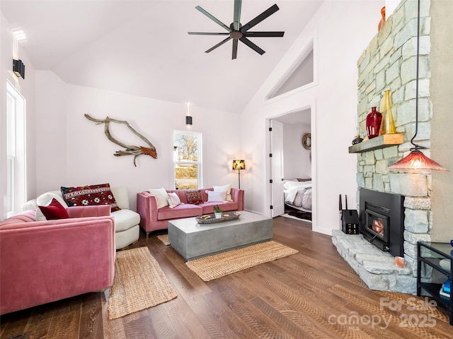 living room with dark wood-type flooring, a fireplace, high vaulted ceiling, and a ceiling fan