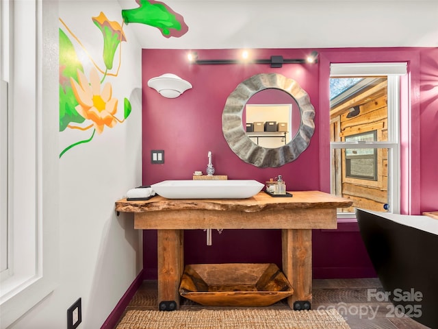 bathroom with a sink and baseboards