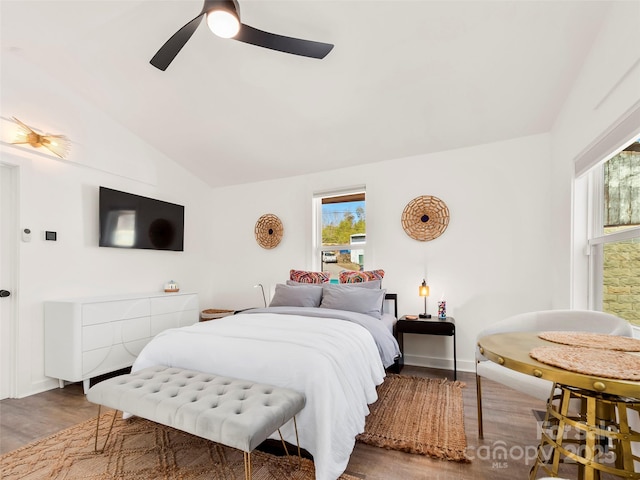 bedroom with ceiling fan, vaulted ceiling, and wood finished floors