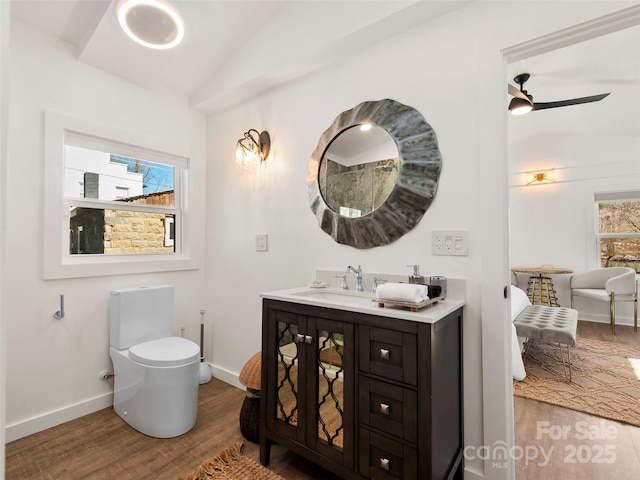 bathroom with lofted ceiling, a healthy amount of sunlight, toilet, and wood finished floors