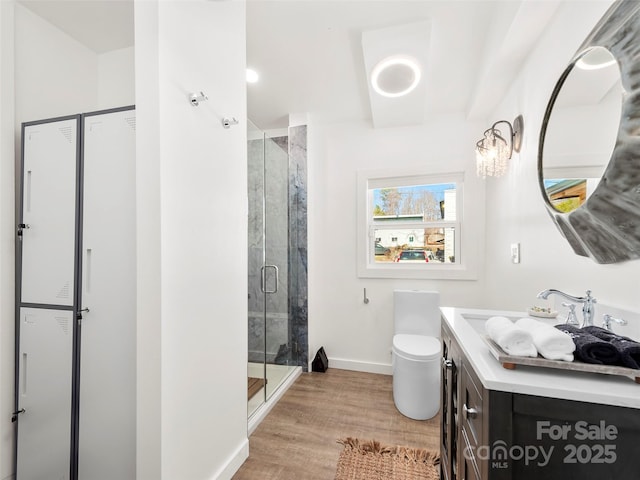full bathroom with toilet, wood finished floors, vanity, baseboards, and a shower stall