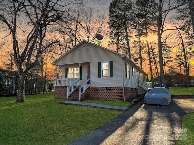 bungalow-style home with covered porch, a front lawn, crawl space, and stairway