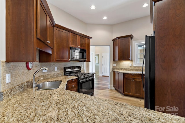 941 Wash Freeman Rd, Hendersonville, NC 28792 - kitchen featuring black appliances, a sink, light stone counters, light wood-style floors, and tasteful backsplash