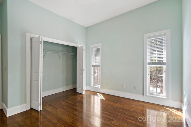 941 Wash Freeman Rd, Hendersonville, NC 28792 - unfurnished bedroom with multiple windows, hardwood / wood-style floors, and baseboards