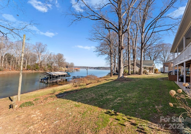 view of yard with a water view and a boat dock