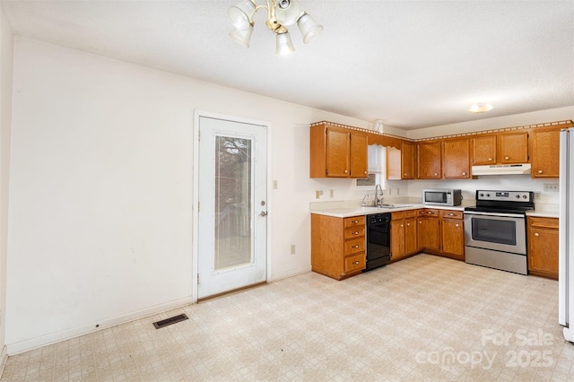 kitchen featuring under cabinet range hood, stainless steel appliances, a sink, visible vents, and light floors