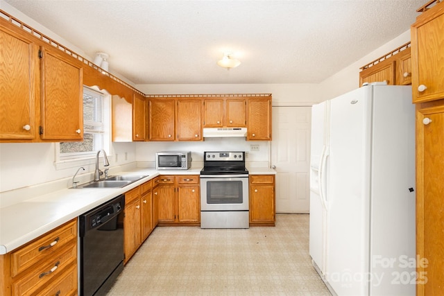 kitchen featuring brown cabinets, light floors, stainless steel appliances, a sink, and under cabinet range hood