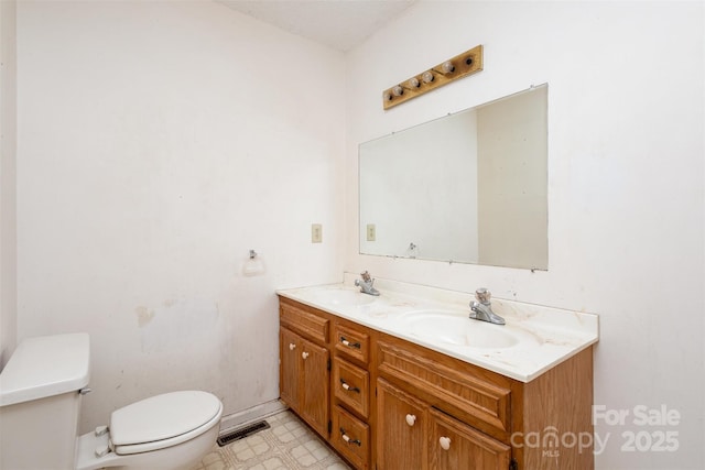 bathroom with visible vents, a sink, toilet, and double vanity