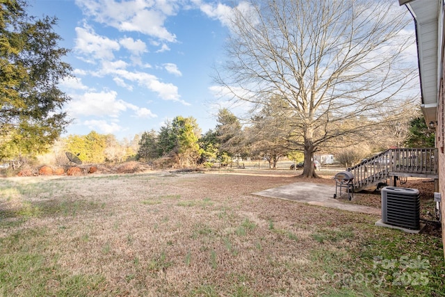 view of yard with central AC, a patio, and stairway