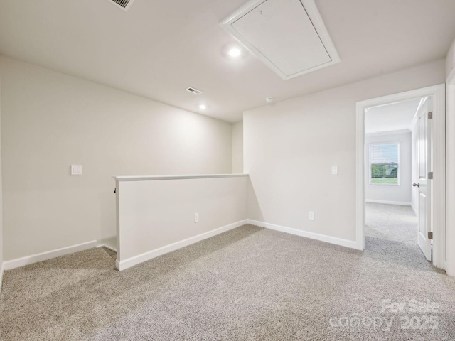 carpeted spare room featuring attic access, visible vents, baseboards, and recessed lighting