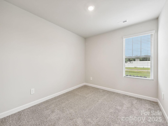 spare room featuring carpet floors, recessed lighting, visible vents, and baseboards