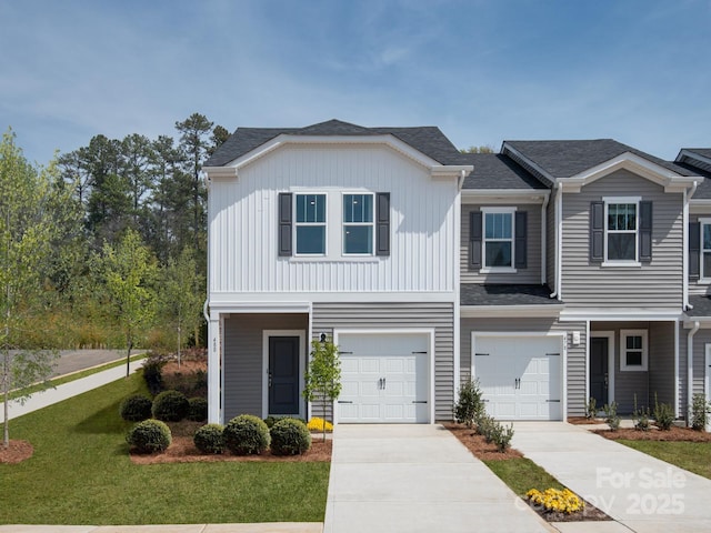 multi unit property featuring concrete driveway, an attached garage, and a front lawn