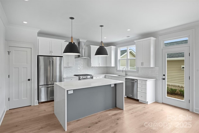 kitchen featuring a center island, light countertops, appliances with stainless steel finishes, white cabinets, and a sink