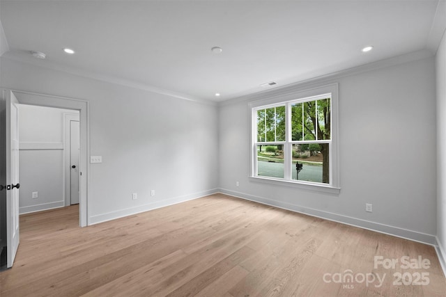 empty room featuring light wood-style floors, baseboards, ornamental molding, and recessed lighting