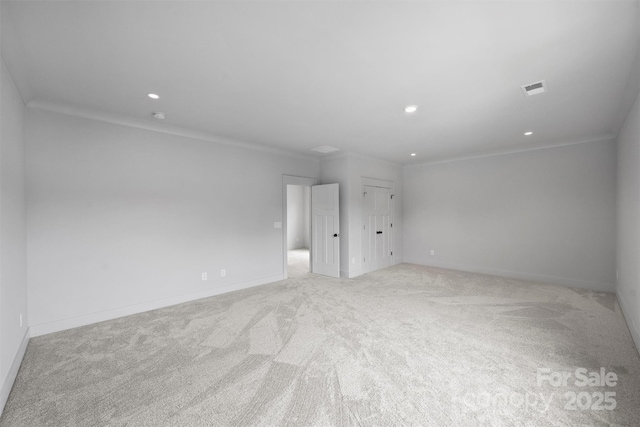 empty room with light carpet, visible vents, crown molding, and recessed lighting